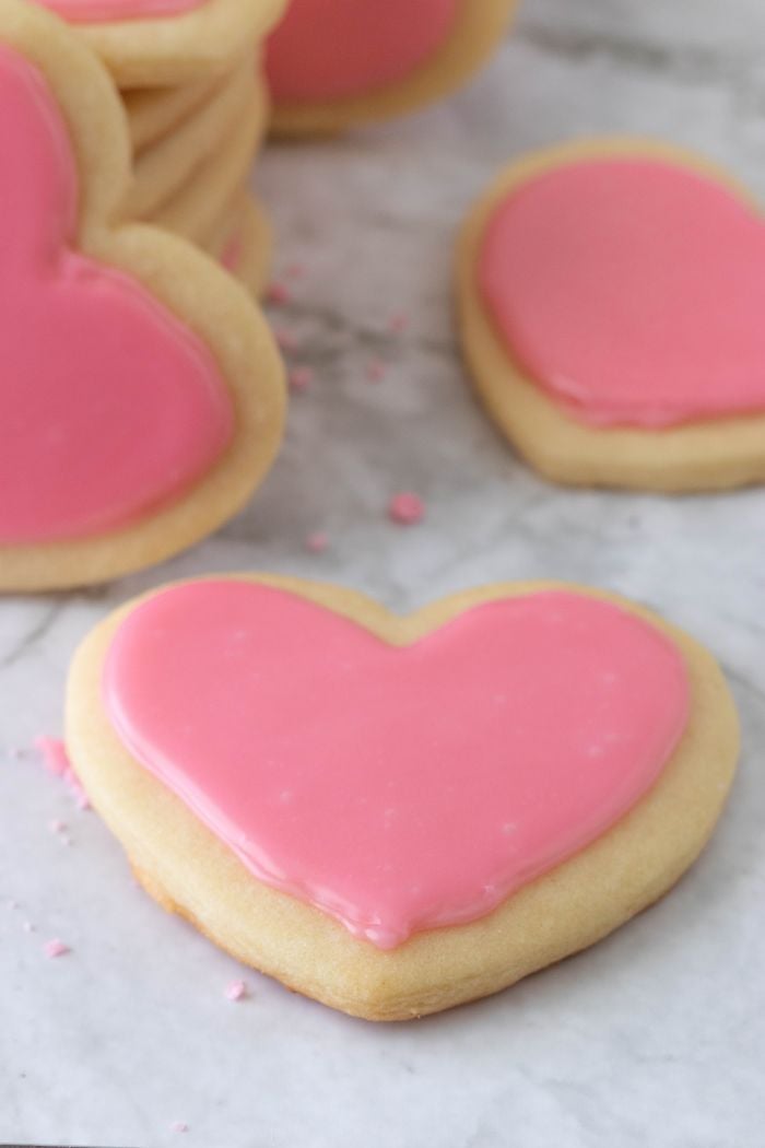 a close up of a heart shaped cookie with pink frosting
